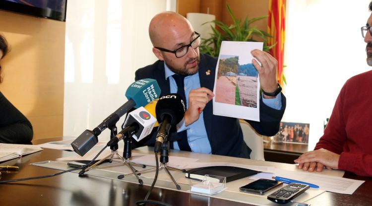 L'alcalde de Lloret, Jaume Dulsat, comentant una fotografia dels danys reparats. ACN