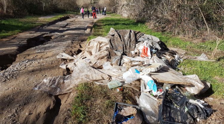 Pla mitjà de diverses bosses d'escombraries plenes a la llera del Fluvià a Besalú