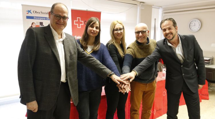 Els organitzadors del curs de planxisteria industrial i mecanització agafant-se la mà a la seu de Creu Roja Girona. ACN