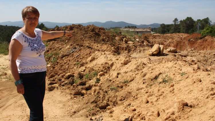 L'alcaldessa de Vilademuls, Dolors Rovirola, al costat d'un dels moviments de terres que s'han deixat a mig fer © ACN