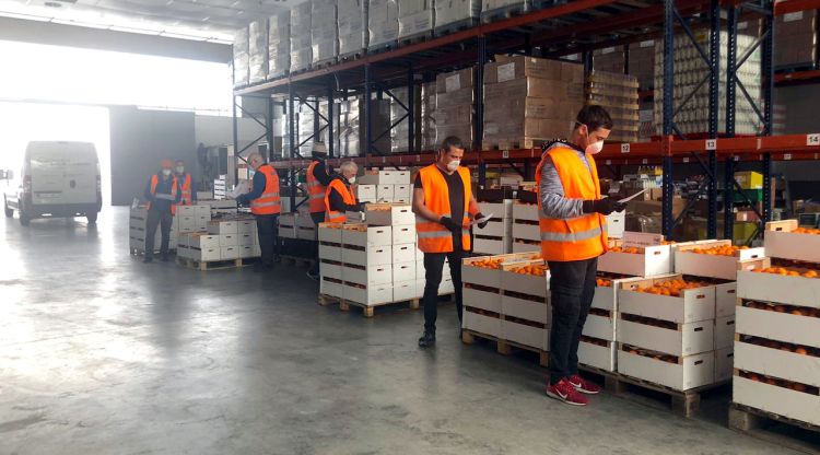 Voluntaris del Banc dels Aliments de Girona preparant els lots a la nau que l'entitat té al barri de Vila-roja