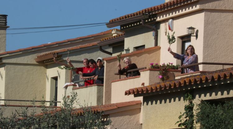 Uns veïns amb branques d'olivera després de cantar l'Hosanna a Verges des del balcó. ACN