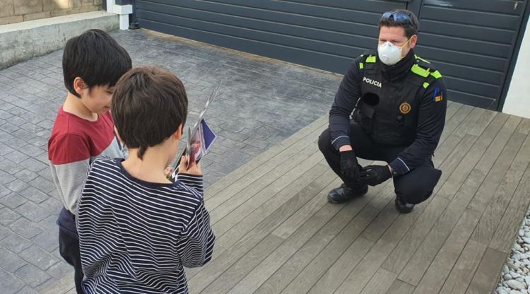 Un agent felicitant a un nen de Palafrugell