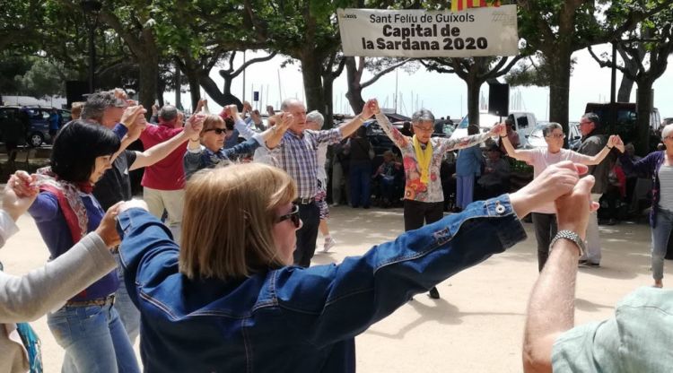 Diversos sardanistes ballant en el passeig de Sant Feliu de Guíxols
