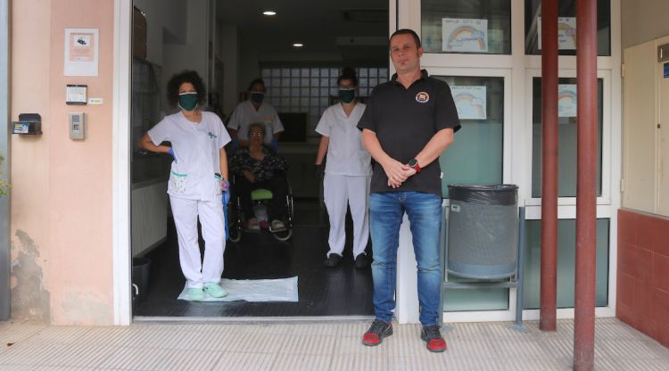 El president de la penya del Barça de Monells, Benet Cuyàs, amb treballadores de la residència a l'entrada del centre. ACN