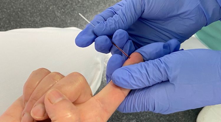 Una treballadora agafant una mostra de sang per fer un test ràpid sobre el coronavirus