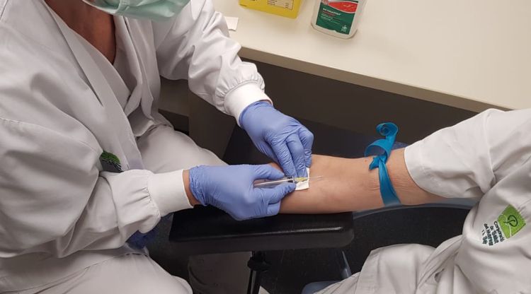 Personal santiari extraient sang a un treballador per fer un test ràpid
