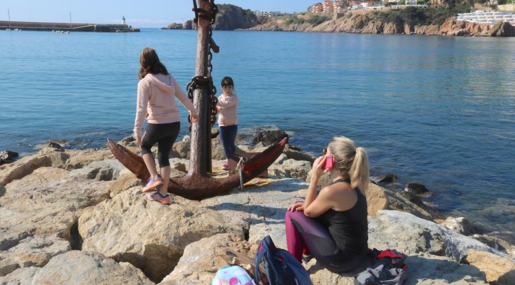 Una mare amb les seves dues filles a tocar de l'aigua a Sant Feliu de Guíxols, ahir. Leyre Barceló