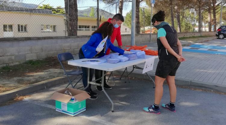 Una dona recollint una mascareta per a un menor de 14 anys que reparteix l'Ajuntament de Riells i Viabrea. ACN