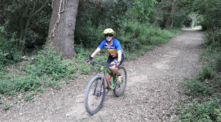 Una ciclista en una pista forestal al Pla de l'Estany. ACN