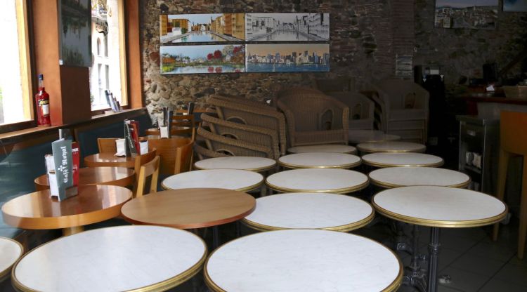Taules i cadires de la terrassa amuntegades dins un local tancat de la plaça Independència de Girona. ACN