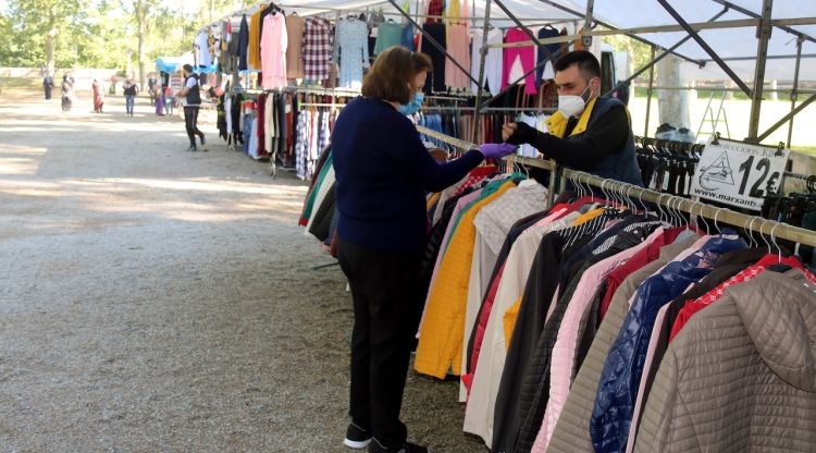 Un marxant ven una peça de roba a una clienta al mercat de la Devesa de Girona, aquest matí. ACN