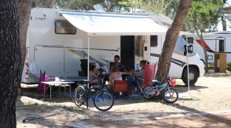 Una família jugant en el Càmping Palamós després d'haver aparcat l'autocaravana