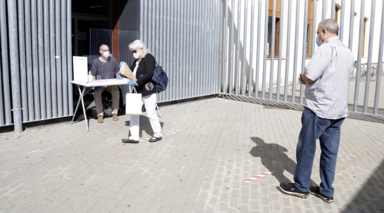 Cua amb distància de seguretat per recollir llibres en préstec a la biblioteca Salvador Allende de Girona. ACN