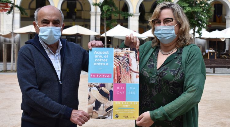 El president i la vicepresident de Girona Centre Eix Comercial amb la imatge de campanya avui a la plaça de la Independència de Girona