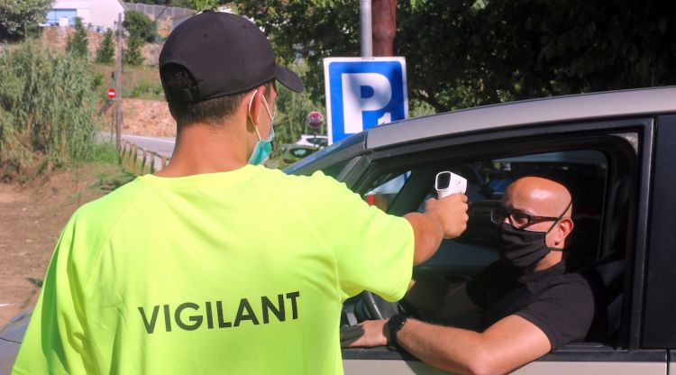 Un vigilant d'un aparcament de Tossa de Mar pren la temperatura a un conductor. ACN