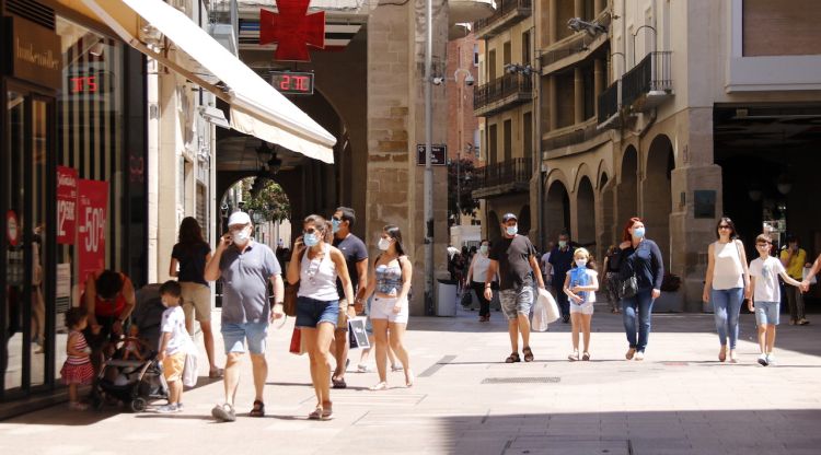 Diverses persones passejant amb mascareta per l'Eix Comercial de Lleida, a l'alçada de la plaça de la Paeria el 5 de juliol. ACN