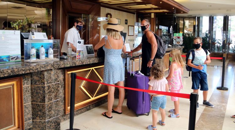 Una família estrangera realitzant el check-in a l'hotel Evenia Olympic de Lloret de Mar. ACN