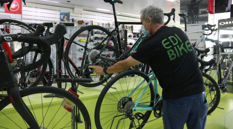 Un treballador d'una botiga de bicicletes de Figueres remenant una de les que té exposades. ACN