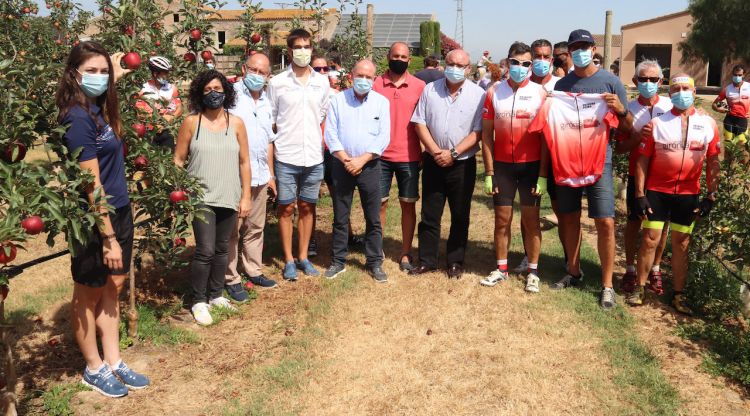 Els productors de Poma de Girona acompanyats per diversos ciclistes en la recollida de la primera poma, avui. ACN