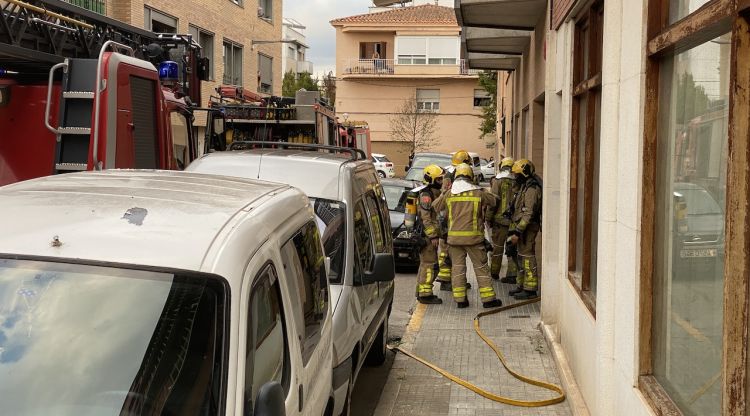 Els Bombers després d'apagar les flames, a l'entrada de l'immoble. M. Estarriola