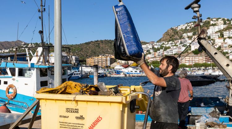 Un pescador buidant alguns dels residus que s'han trobat a alta mar en el Port de Roses. ACN