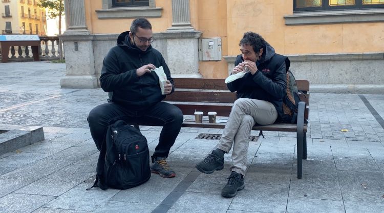 Dos homes esmorzant en un banc després de demanar el menjar en un bar de la Rambla de Girona. M. Estarriola