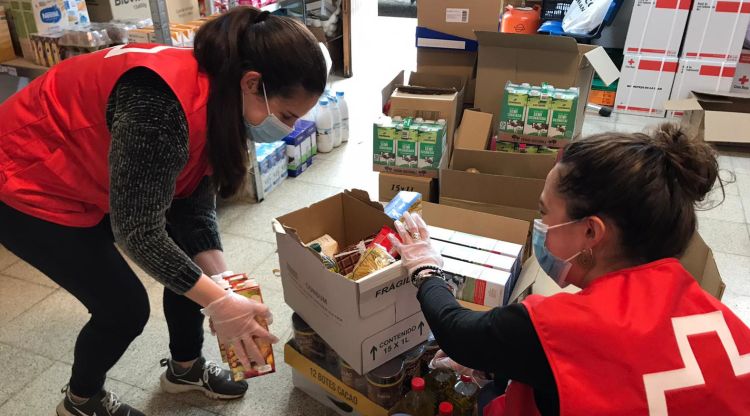 Dues voluntàries de la Creu Roja preparant aliments per a persones vulnerables