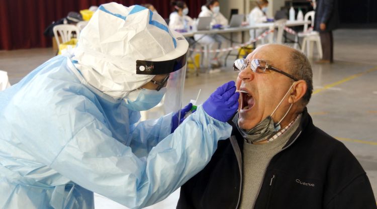 Un home fent-se la prova PCR amb un tècnic sanitari al pavelló de l'Oli de les Borges Blanques. ACN