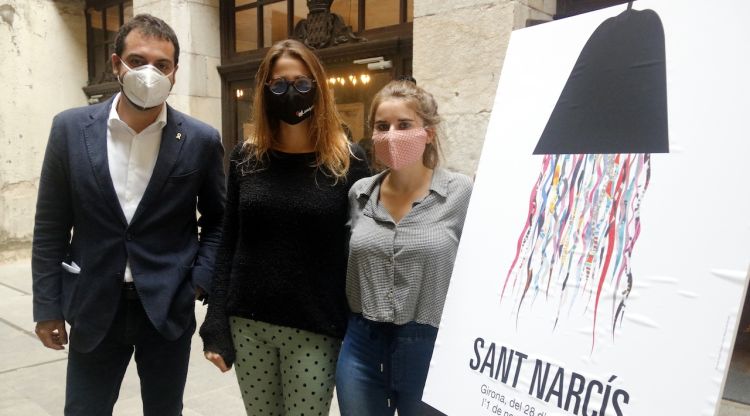 El vicealcalde i regidor de Cultura, Quim Ayats, al costat de les integrants del col·lectiu 'La noia del monyo' amb el cartell de Sant Narcís. ACN