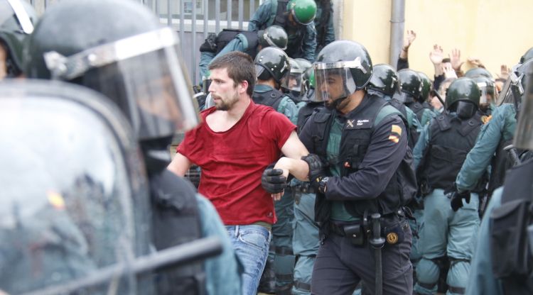 Un agent de la Guàrdia Civil s'endú un concentrat favorable al referèndum a Sant Cebrià de Vallalta. ACN