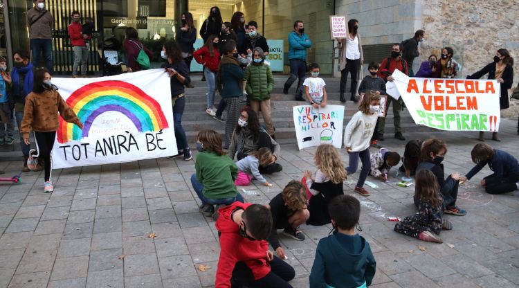 Diversos nens dibuixant mascaretes al terra amb una creu a sobre mentre els pares demanen a Educació que no obligui als alumnes a portar-ne a l'aula. ACN