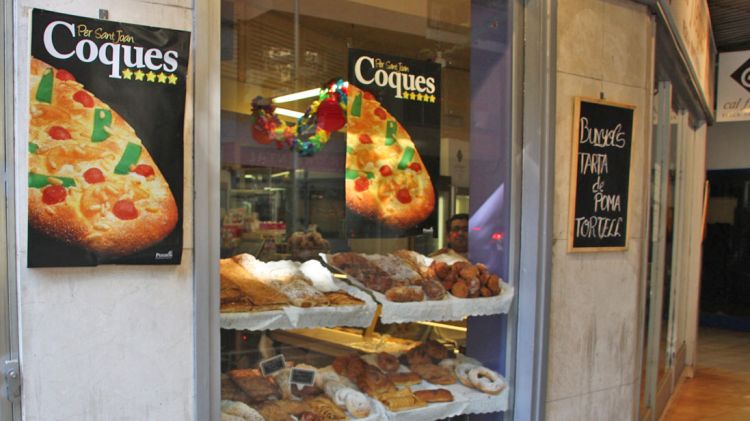 Un aparador d'una pastisseria de Girona on s'anuncia la coca de Sant Joan © ACN