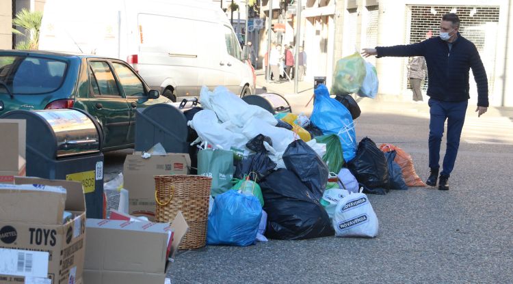 Un home llençant una bossa d'escombraries a Figueres. ACN