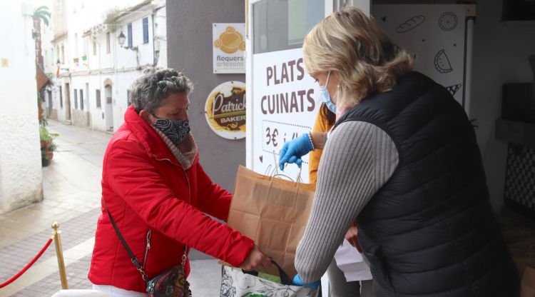Una de les dones en situació vulnerable de Tossa de Mar rebent un menú solidari de Patrick's Bakery. ACN