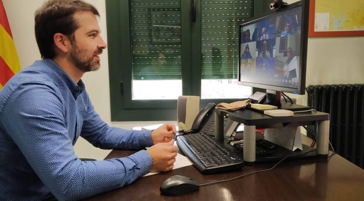 El president del Consell Comarcal del Ripollès, Joaquim Colomer, davant l'ordinador amb la pantalla d'alguns autoritats de la reunió telemàtica