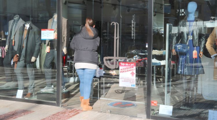 Una treballadora obrint la porta del comerç de Platja d'Aro, aquest matí. ACN