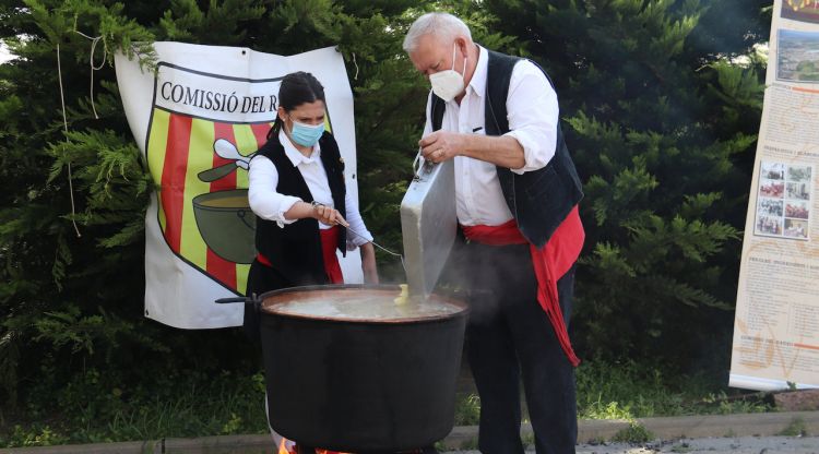 Dos memebres de la Comissió del Ranxo de Vidreres tirant les patates a la perola. ACN