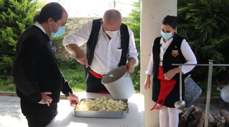 Tres membres de la Comissió del Ranxo de Vidreres preparant les patates abans de tirar-les a l'olla. ACN
