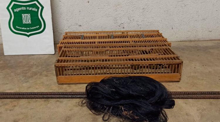 La xarxa japonesa plegada i una gàbia per a ocells que han interceptat els Agents Rurals