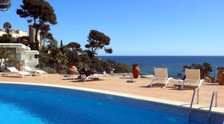La piscina i la terrassa del Parkhotel San Jorge de Calonge, amb dos turistes prenent el sol. ACN