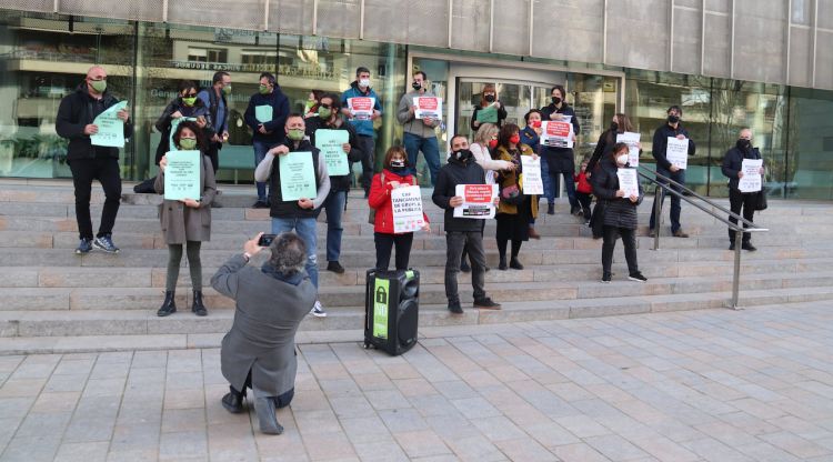 Diverses persones dels sindicats aguantant cartells amb demandes laborals al Departament d'Educació. ACN