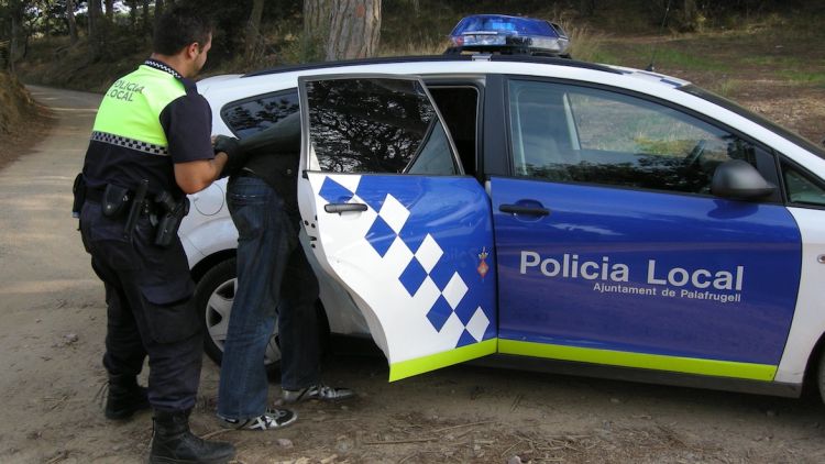 Un agent de la Policia Local de Palafrugell realitzant una detenció en una imatge d'arxiu