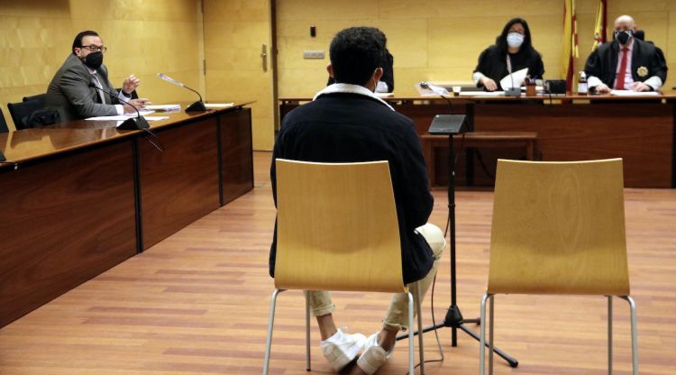 D'esquenes, l'acusat d'abusar sexualment d'una menor de 17 anys a Girona. Foto del judici a l'Audiència de Girona. ACN