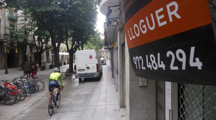 En primer terme, un cartell de lloguer en un local de la Rambla de Girona. ACN