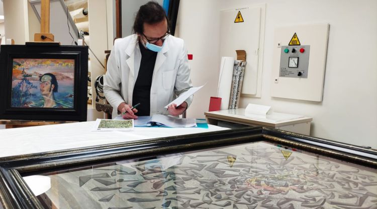Un restaurador comprovant una de les obres de Salvador Dalí que es deixaran en préstac per una exposició a Itàlia