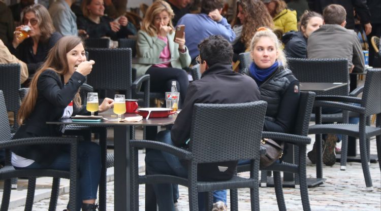 Uns joves en una taula a la terrassa d'un bar de la Plaça Independència de Girona. ACN