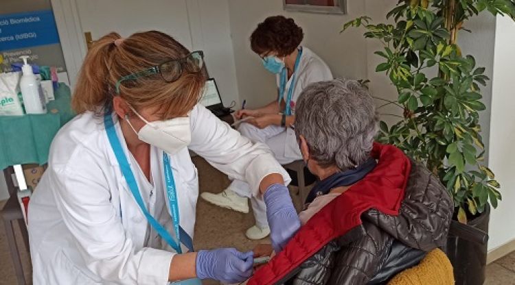 Una sanitària vacunant una pacient amb esclerosi múltiple