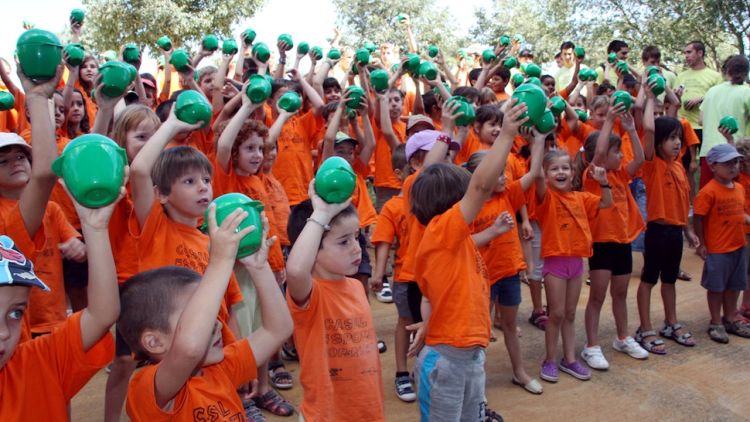 Els nens del casal de Porqueres amb la carmanyola de fruita a les mans © ACN