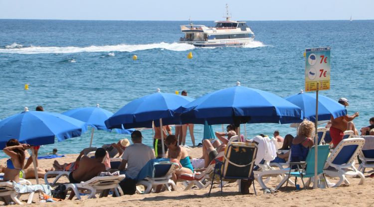 Un grup de turistes amb tumbones a la platja a Lloret de Mar. ACN